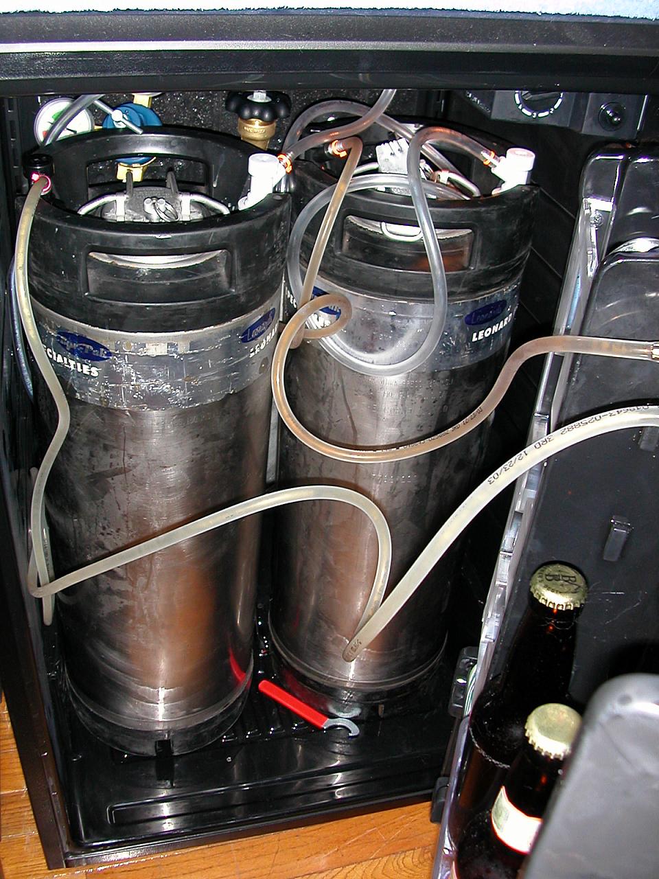 2 kegs tucked away with the faucet wrench on the floor